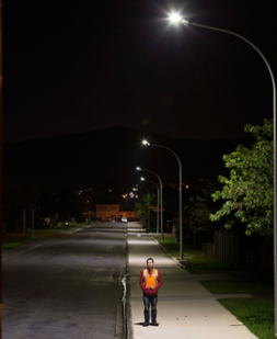 Man standing under LED street light